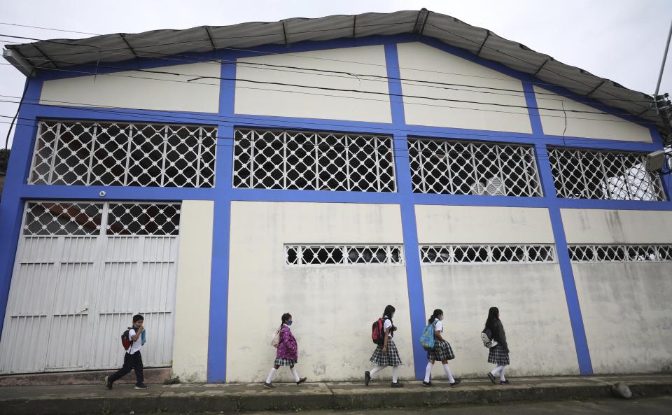 Wearing masks to curb the spread of the new coronavirus, students walk to the only open school in Campohermoso, Colombia, Thursday, March 18, 2021. Campohermoso is one of two municipalities in Colombia that has not had a single case of COVID-19 since the pandemic started one year ago, with the student body at the school rotating half the students into their classrooms while the other attends via the internet. (AP Photo/Fernando Vergara)