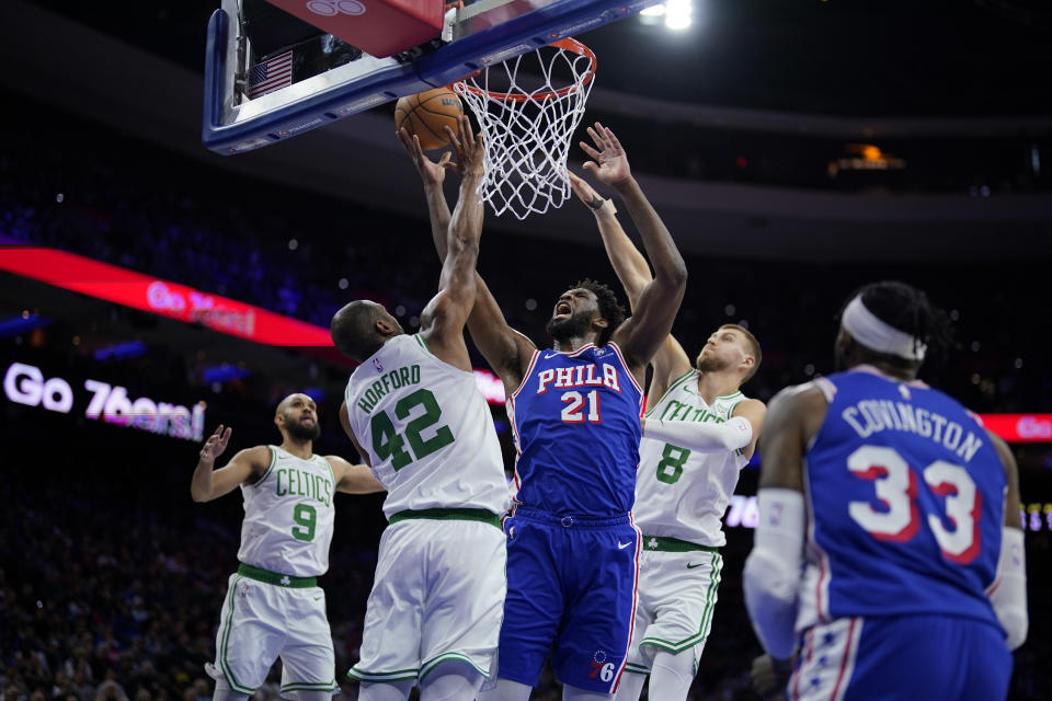 Philadelphia 76ers' Joel Embiid (21) goes up for a shot against Boston Celtics' Al Horford (42) and Kristaps Porzingis (8) during the first half of an NBA basketball game, Wednesday, Nov. 8, 2023, in Philadelphia. (AP Photo/Matt Slocum)