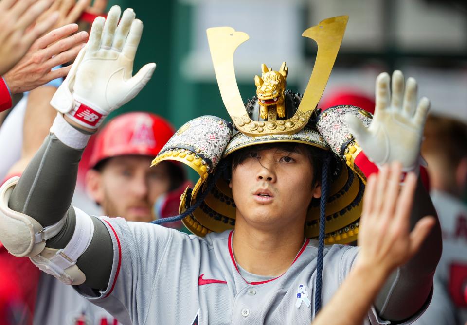 Angels' Shohei Ohtani is congratulated by teammates after hitting a home run.