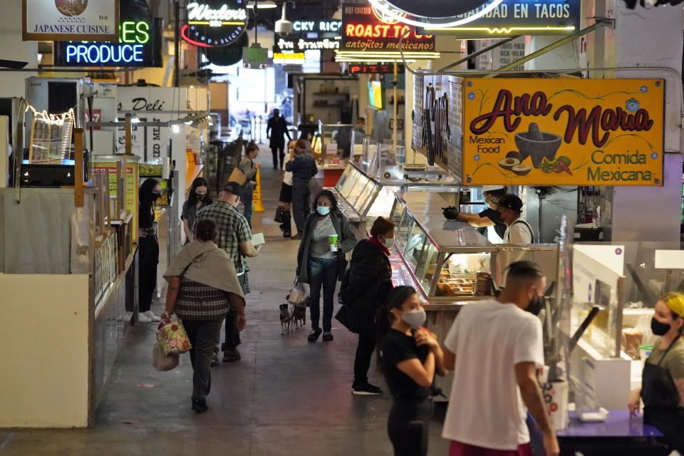 Customers walk the aisles at the Grand Central Market Monday, Nov. 16, 2020, in Los Angeles. California Gov. Gavin Newsom announced Monday, Nov. 16, 2020, that due to the rise of COVID-19 cases, Some counties have been moved to the state's most restrictive set of rules, which prohibit indoor dining. The new rules begin, Tuesday, Nov. 17. (AP Photo/Marcio Jose Sanchez)
