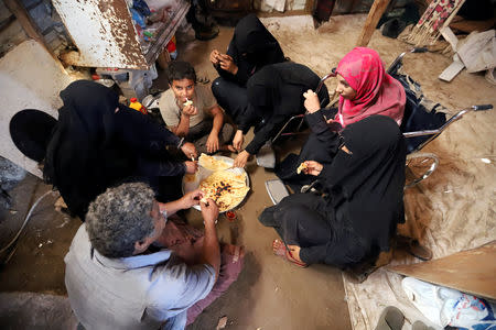 Ahmed Ali Ghaleb Kassem, 48, has breakfast with his family on Salam Street in north Hodeidah, Yemen March 25, 2019. REUTERS/Abduljabbar Zeyad