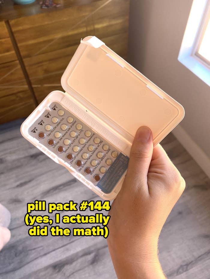 The writer holding a pack of birth control pills labeled "pill pack #144 (yes, I actually did the math)"