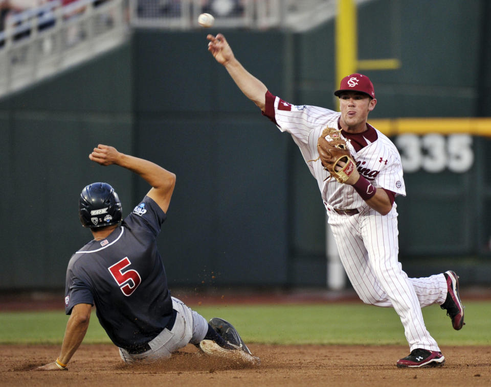 South Carolina shortstop Joey Pankake throws to first but cannot complete a double play after forcing out Arizona's Seth Mejias-Brean in the seventh inning of Game 2 of the NCAA College World Series baseball finals in Omaha, Neb., Monday, June 25, 2012. Arizona's Bobby Brown reached first base on a fielder's choice. (AP Photo/Ted Kirk)