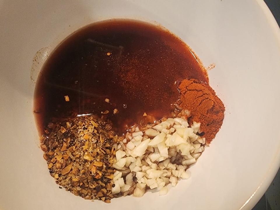 Marinade with vinegar, oil, and spices in a bowl