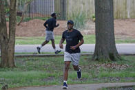 Runners take advantage of the 1-mile Parham Bridges walking track, Monday, March 23, 2020, in Jackson, Miss. Runners across the country are still hitting the pavement and the trails, staying fit and working off some stress amid the coronavirus pandemic. It also provides a social outlet in a time when the sports world has mostly been shut down and officials are encouraging social distancing. (AP Photo/Rogelio V. Solis)