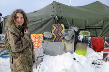 A veteran stands in front of homemade shields in Oceti Sakowin camp as "water protectors" continue to demonstrate against plans to pass the Dakota Access pipeline near the Standing Rock Indian Reservation, near Cannon Ball, North Dakota, U.S. December 3, 2016. REUTERS/Stephanie Keith