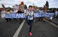 <p>A woman talks on a loudspeaker as people hold a large anti-Trump banner and other signs on July 14, 2018, in Edinburgh, Scotland. (Photo: Jeff J. Mitchell/Getty Images) </p>