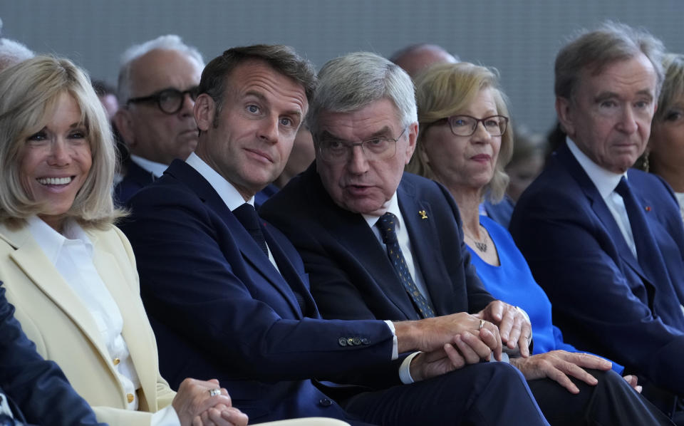 El presidente del COI, Thomas Bach, al centro, el presidente francés, Emmanuel Macron, al centro izquierda, su esposa Brigitte Macron, a la izquierda, y el director ejecutivo de LVMH, Bernard Arnault, a la derecha, sentados, durante la ceremonia de apertura de la sesión del COI en la Fundación Louis Vuitton antes de los Juegos Olímpicos de Verano de 2024 el 22 de julio de 2024, en París, Francia. (Foto AP/Thibault Camus)