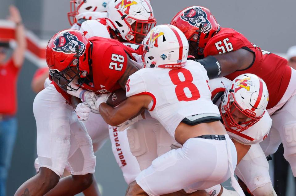 N.C. State running back Demarcus Jones II (28) scores on a two-yard touchdown run as Virginia Military Institute safety Nic Land (8) tries to stop him during the second half of the Wolfpack’s 45-7 victory over VMI at Carter-Finley Stadium in Raleigh, N.C., Saturday, Sept. 16, 2023.