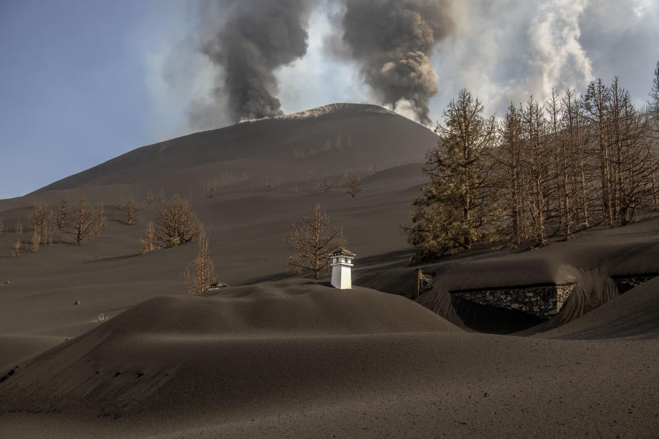 A house is covered with the ash from the volcano in Las Manchas on the Canary island of La Palma, Spain on Thursday Oct. 14, 2021. Hundreds of people in Spain's Canary Islands are fearing for their homes and property after a new lava stream from an erupting volcano threatened to engulf another neighborhood on the island of La Palma. (AP Photo/Saul Santos)