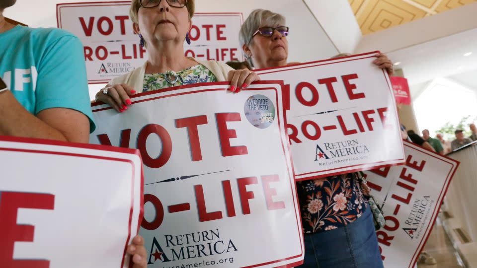 Anti-abortion supporters hold signs as they wait to enter the North Carolina Senate gallery in Raleigh on May 16, 2023. - Chris Seward/AP/File