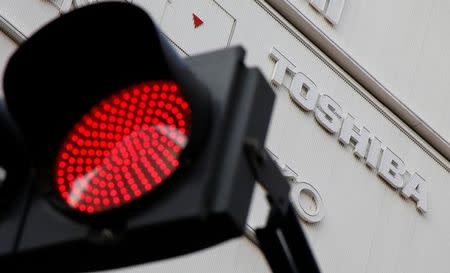 A logo of Toshiba Corp is seen behind a red light signal outside an electronics retail store in Tokyo, Japan, January 19, 2017. REUTERS/Toru Hanai