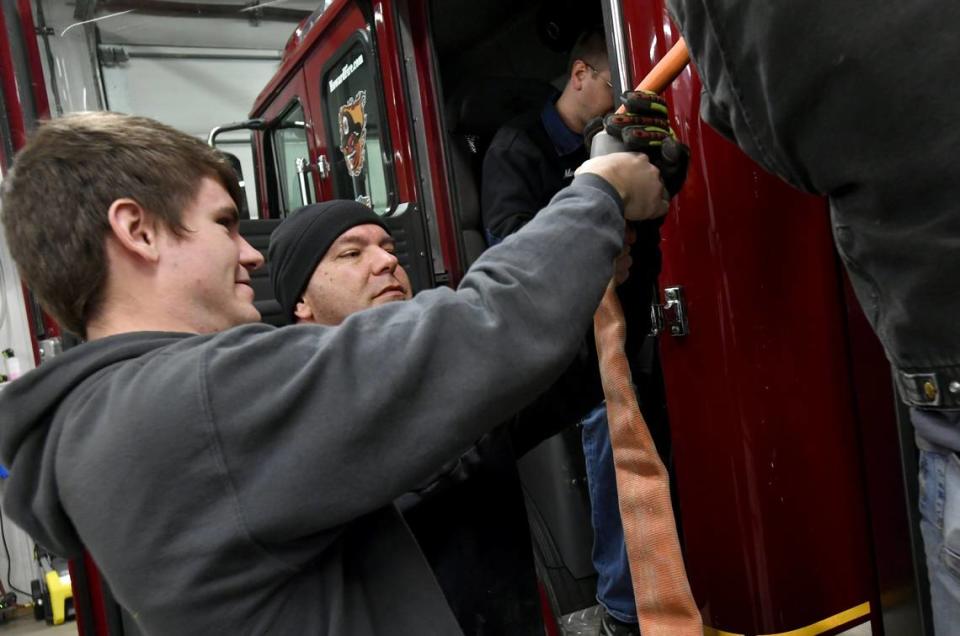 Caleb Kelley and Rich Kelley work together to load hoses on the engine at Howard Fire Department during a work night on Jan. 24, 2019. Rich Kelley talked of how proud he was that his son Caleb, now 20, joined the company when he was 14.