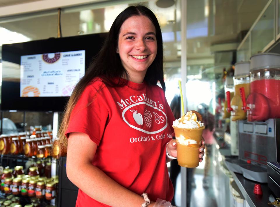 McCallum’s Orchard and Cider Mill employee Karissa Fay serves a customer a deluxe cider slushy at the pod at the Lot venue at Fourth and Water streets in downtown Port Huron on Friday, July 8, 2022.
