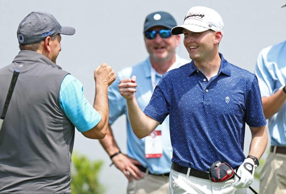 NASCAR Cup Series driver William Byron, right, bumps fists with a member of his team prior to teeing off at the first tee during the Wells Fargo Championship Pro-Am at Quail Hollow Club on Wednesday, May 8, 2024.