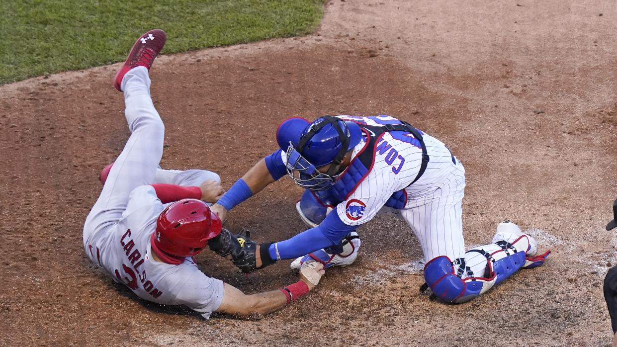  Chicago Cubs player stretches to tags a rival at Wrigley Field ahead of this week's huge Cubs vs Cardinals showdown. 