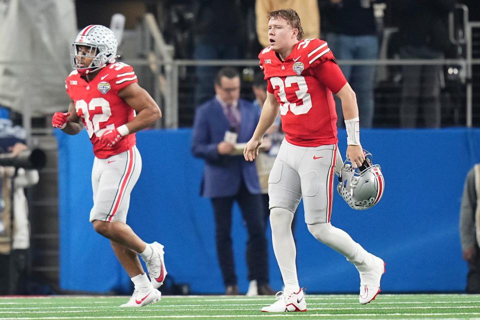 Dec 29, 2023; Arlington, Texas, USA; Ohio State Buckeyes quarterback Devin Brown (33) limps off the field beside running back TreVeyon Henderson (32) during the second quarter of the Goodyear Cotton Bowl Classic against the Missouri Tigers at AT&T Stadium.