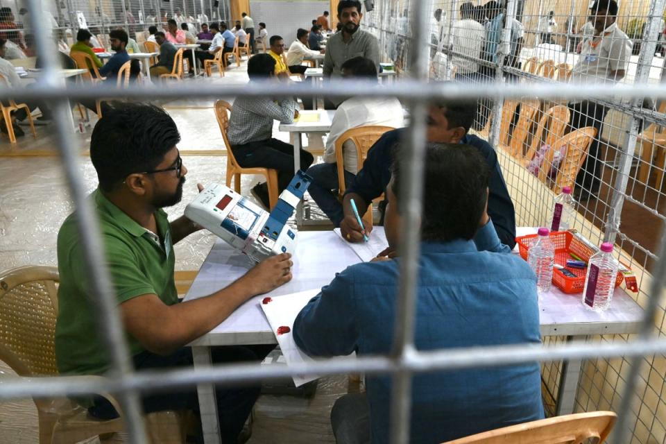 Election workers count votes from an electronic voting machine in Mumbai (AFP via Getty)