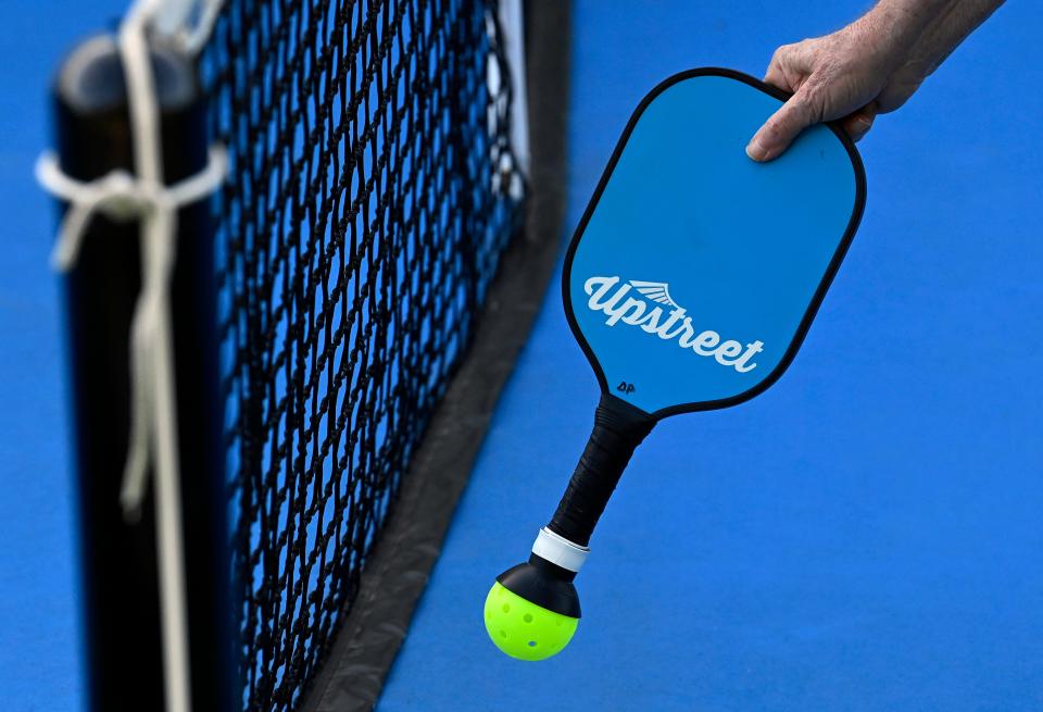 A player uses his paddle to pick up a pickleball the Williamson County Indoor Sports Complex in Brentwood. Pickleball is a growing in popularity across the country.