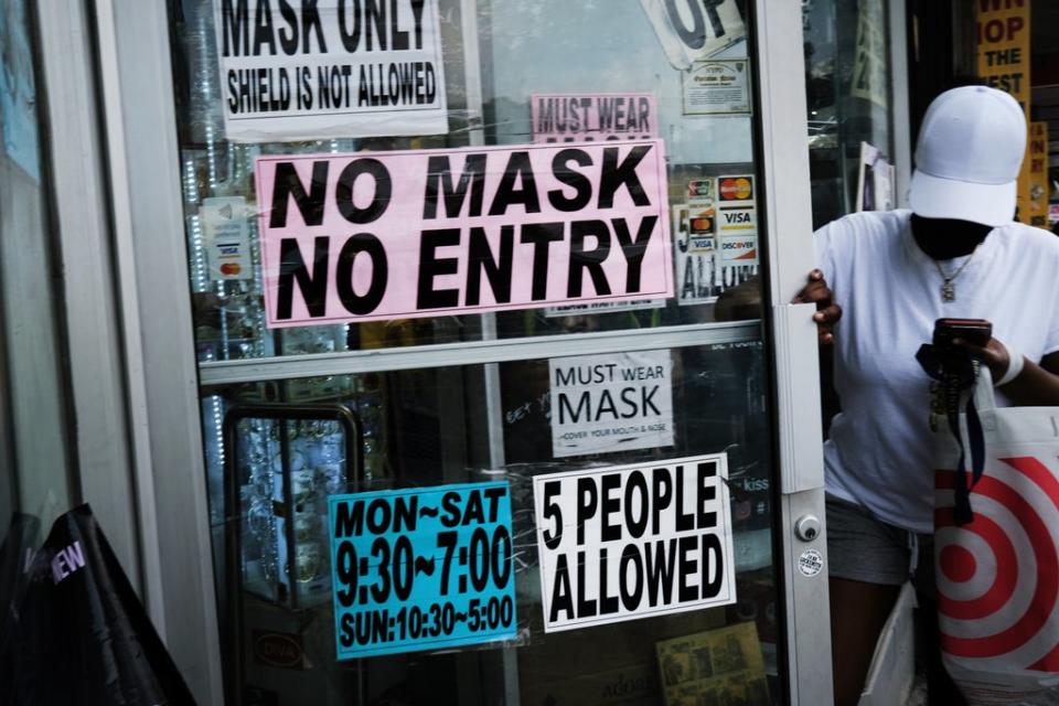  People walk out of a store requesting that people wear masks on July 26, 2021 in the Brooklyn borough of New York City. (Getty Images)