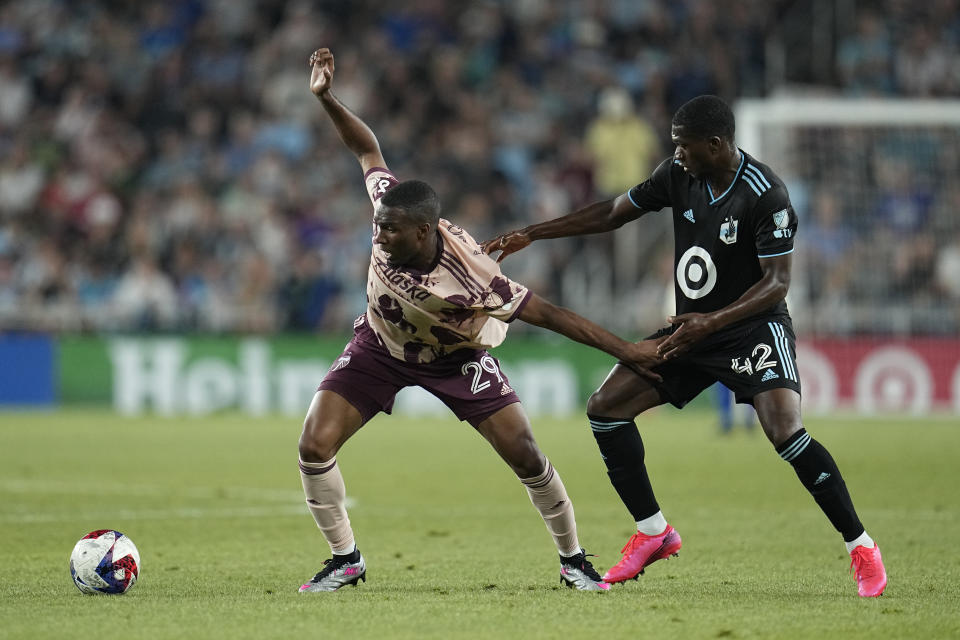 Portland Timbers defender Juan David Mosquera, left, and Minnesota United forward Emmanuel Iwe, right, battle for possession during the second half of an MLS soccer match, Saturday, July 1, 2023, in St. Paul, Minn. (AP Photo/Abbie Parr)