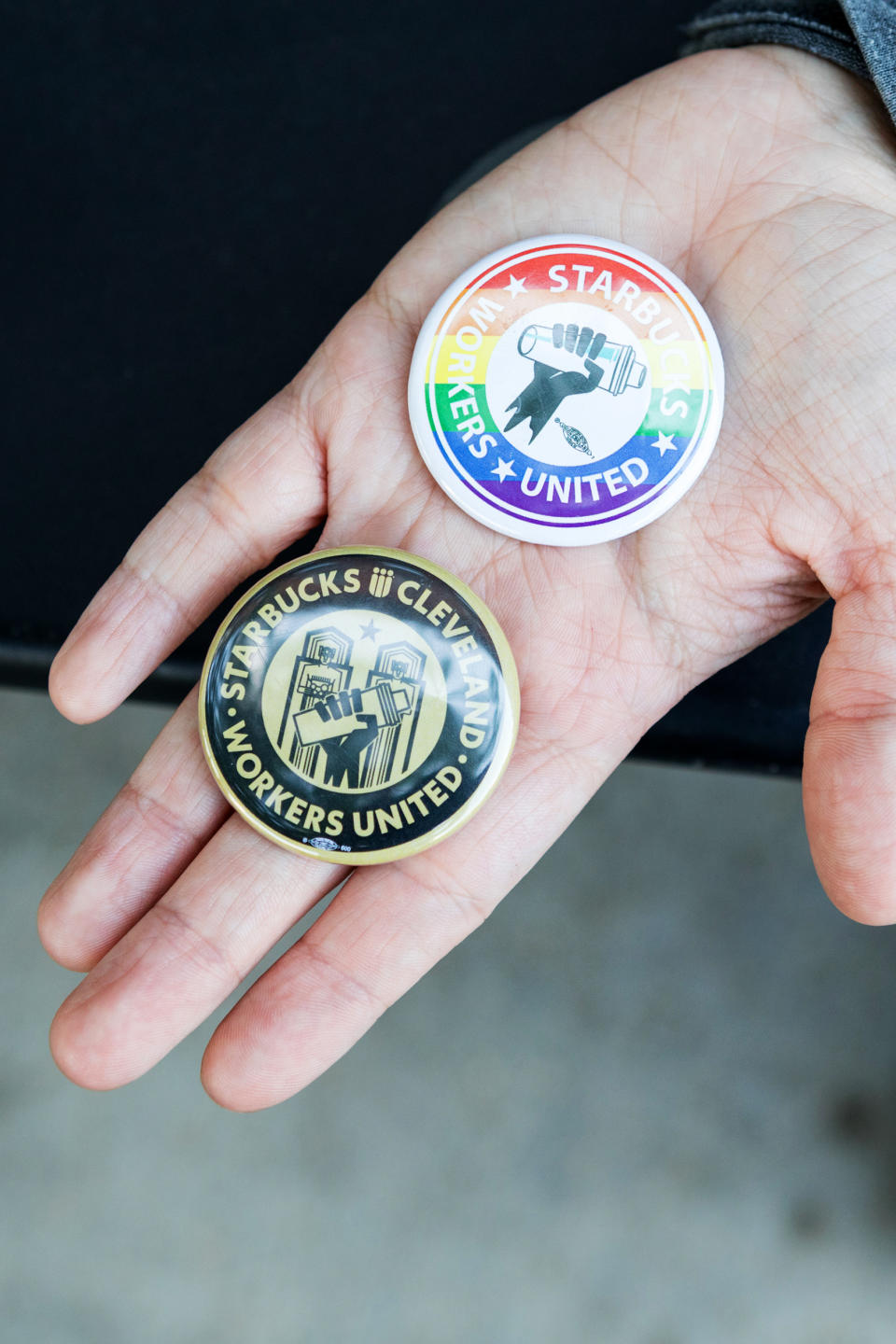 Starbucks coffee supervisor Maddie Vanhook holds Starbucks Workers United pins, in Cleveland, on May 19. (Amber N. Ford for NBC News)