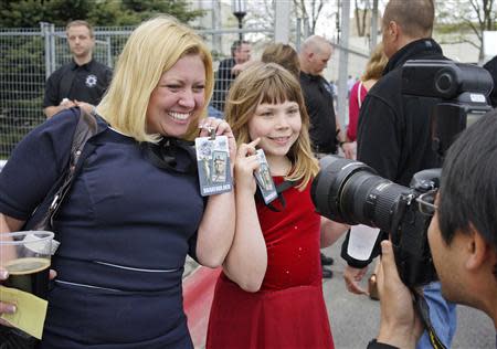 Berkshire Hathaway shareholders display their badges to a news photographer at a welcome cocktail reception in Omaha, Nebraska May 2, 2014, in the lead up to the Berkshire Hathaway annual meeting on May 3, 2014. REUTERS/Rick Wilking