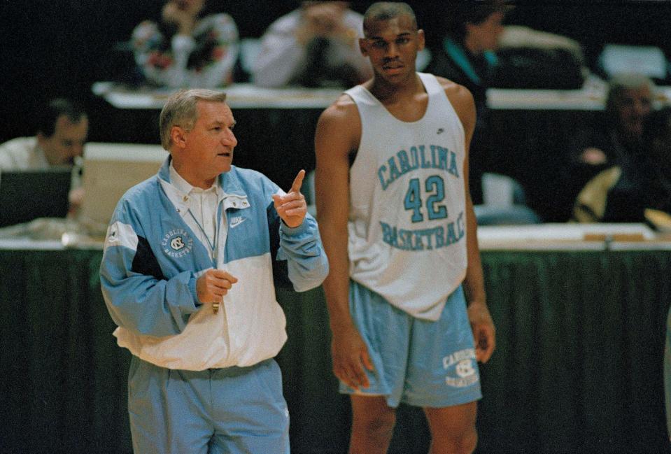 North Carolina basketball coach Dean Smith guides his team during practice as forward Jerry Stackhouse looks on, March 17, 1994. North Carolina meets Liberty University in Landover, Md. (AP Photo/Ted Mathias)