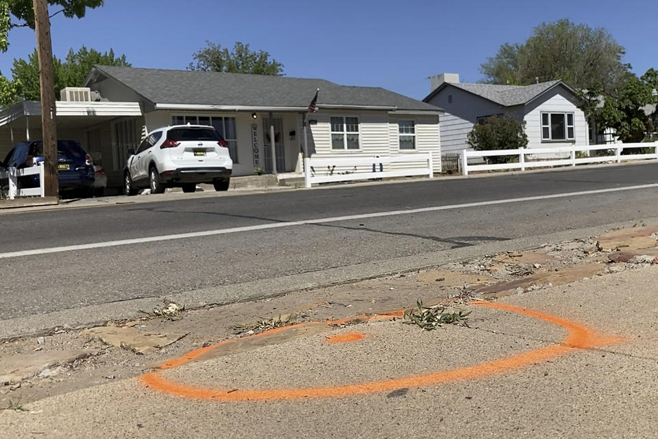 A spray-painted circle marks a location where evidence was collected along a residential street from a deadly shooting in Farmington, New Mexico after authorities opened the roadway Tuesday, May 16, 2023. (AP Photo/Susan Montoya Bryan)