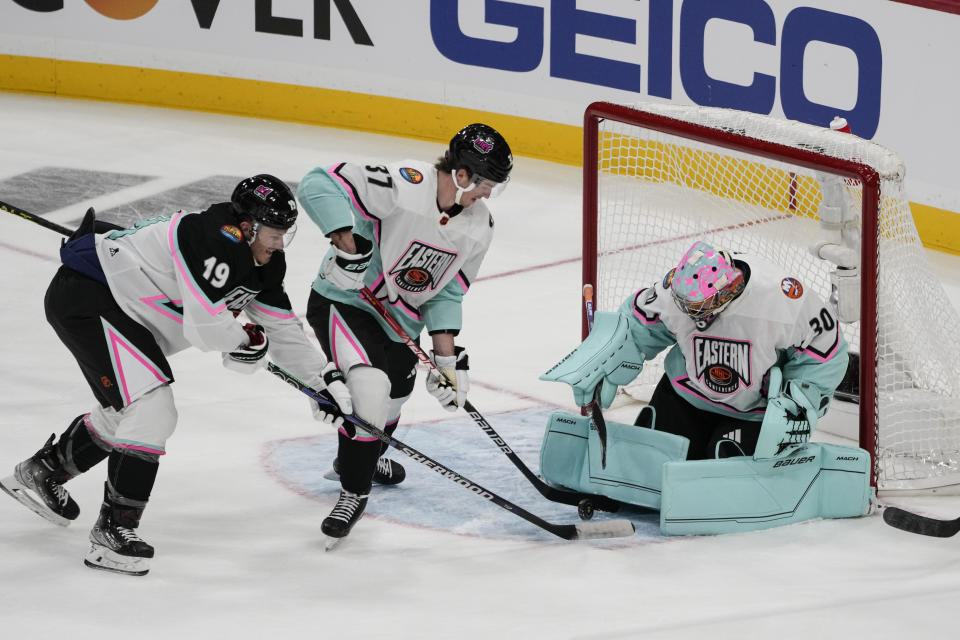 Atlantic Division's Matthew Tkachuk, of the Florida Panthers (19) battles Metropolitan Division's Andrei Svechnikov, of the Carolina Hurricanes (37) and goaltender Ilya Sorokin, of the New York Islanders (30) in front of the goal during the NHL All Star hockey game, Saturday, Feb. 4, 2023, in Sunrise, Fla. (AP Photo/Marta Lavandier)