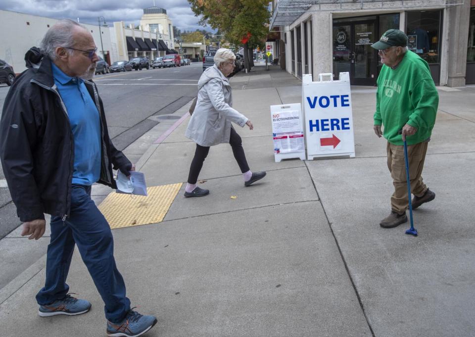 Redding resident Michael Sullivan, 83, right, leaves as another man arrives at the