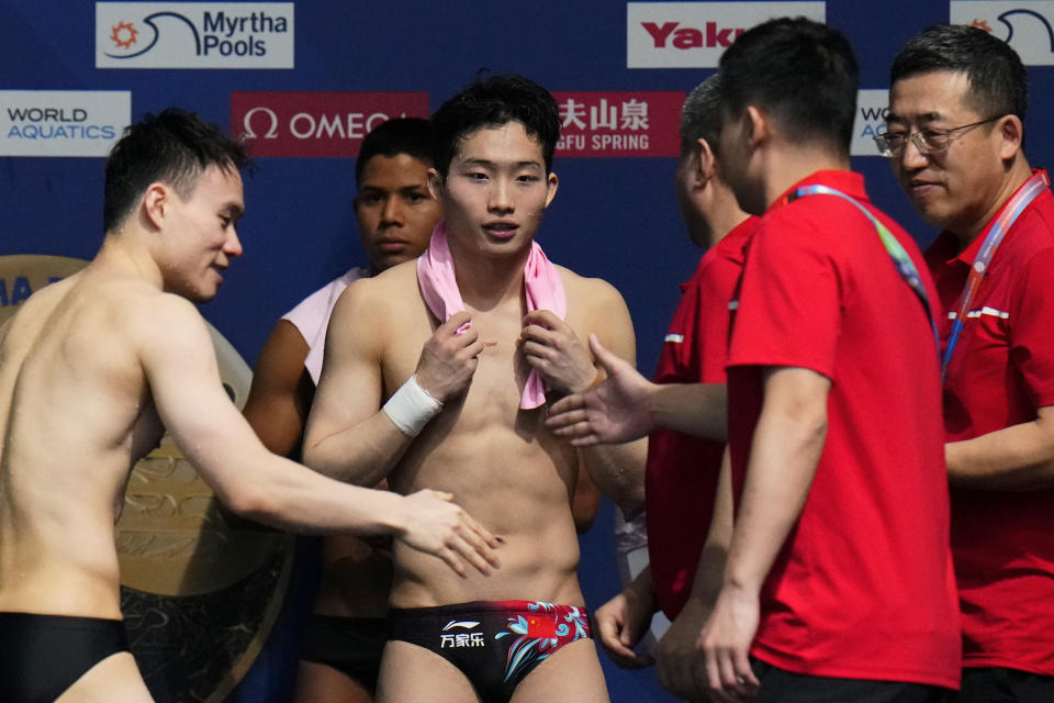 The Chinese team reacts after Wang Zongyuan, centre, won gold and Xie Siyi, left, won silver in the men's 3m springboard diving final at the World Aquatics Championships in Doha, Qatar, Wednesday, Feb. 7, 2024. (AP Photo/Hassan Ammar)