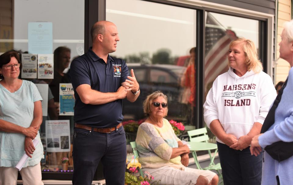 State Sen. Kevin Hertel, D-St. Clair Shores, center, talks with Chris Holcomb, right, and others on Tuesday, Aug. 1, 2023, outside the Island Grind coffee shop and neighboring Readres Cove in Sans Souci.