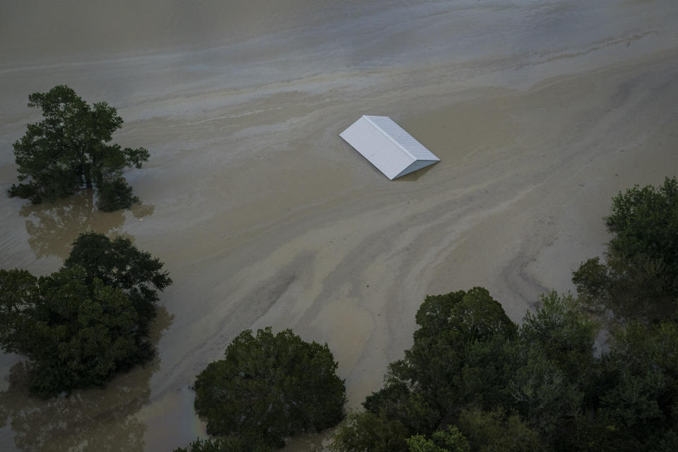 Flood waters and pollution surround submerged buildings.