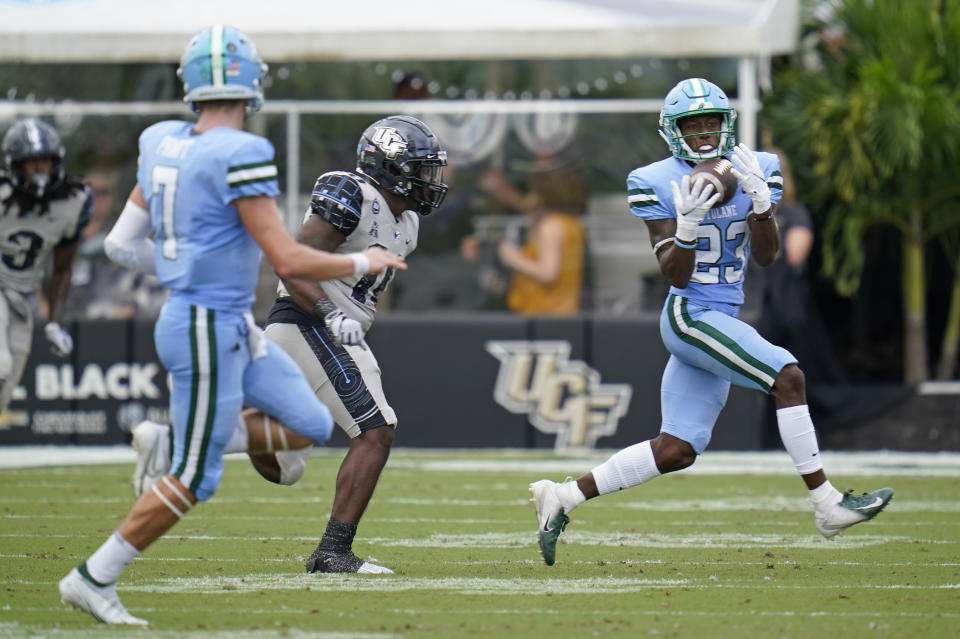 Tulane wide receiver Jaetavian Toles (23) makes a reception off a pass from quarterback Michael Pratt (7) as Central Florida linebacker Eriq Gilyard, center, tries to defend during the first half of an NCAA college football game, Saturday, Oct. 24, 2020, in Orlando, Fla. (AP Photo/John Raoux)