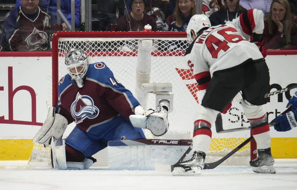 Colorado Avalanche goaltender Alexandar Georgiev, left, stops a shot by New Jersey Devils center Max Willman in the third period of an NHL hockey game on Tuesday, Nov. 7, 2023, in Denver. (AP Photo/David Zalubowski)