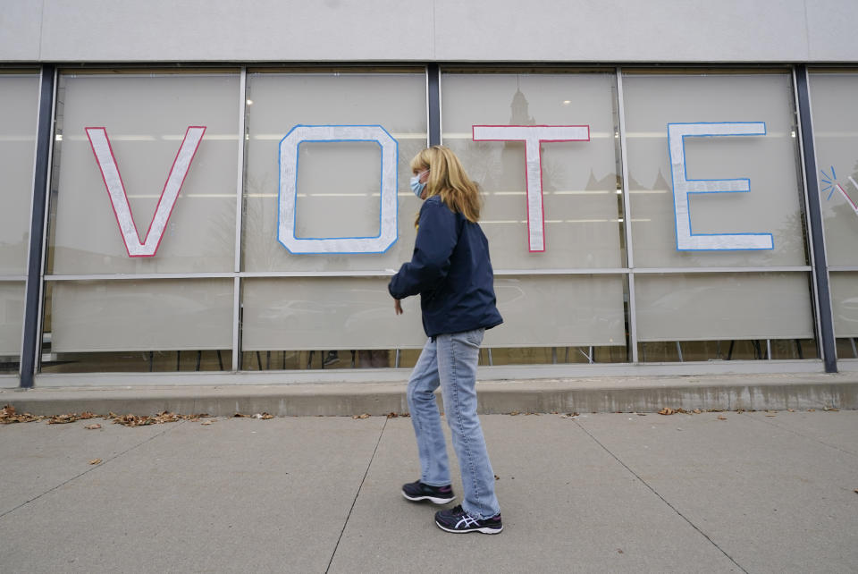 A local resident arrives to cast her ballot during early voting for the general election, Tuesday, Oct. 20, 2020, in Adel, Iowa. (AP Photo/Charlie Neibergall)