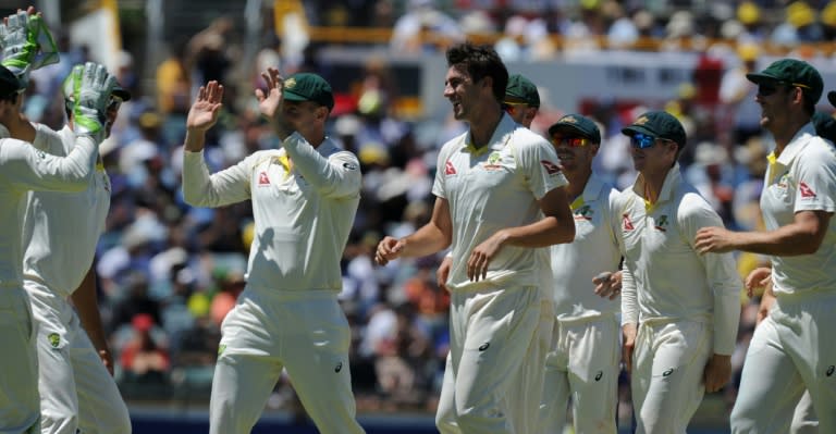 Australia's Pat Cummins (C) celebrates with teammates after dismissing England's Joe Root on day one of their third Ashes Test match, in Perth, on December 14, 2017