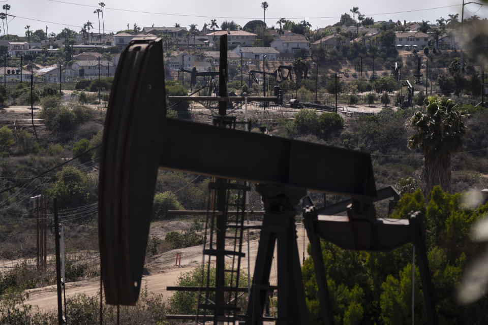 FILE - Homes sit on a hill behind pump jacks operating at the Inglewood Oil Field in Los Angeles, on May 18, 2021. Stop the Energy Shutdown, a campaign organized by oil and gas industry groups, said Tuesday, Dec. 13, 2022, it has collected enough signatures for a referendum to overturn SB 1137, the law that banned new oil and gas wells within 3,200 feet of highly populated places. (AP Photo/Jae C. Hong, File)