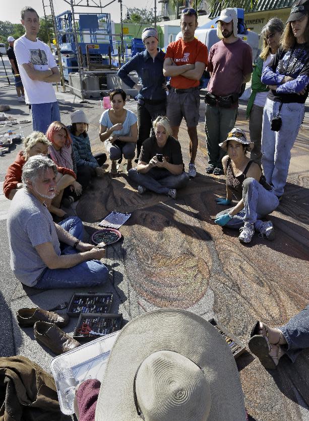 Artist Kurt Wenner, seated left, instructs fellow artist working on his 3D circus pavement art project during the Sarasota Chalk Festival Wednesday, Oct. 31, 2012, in Sarasota, Fla. The festival runs through Nov. 6. (AP Photo/Chris O'Meara)