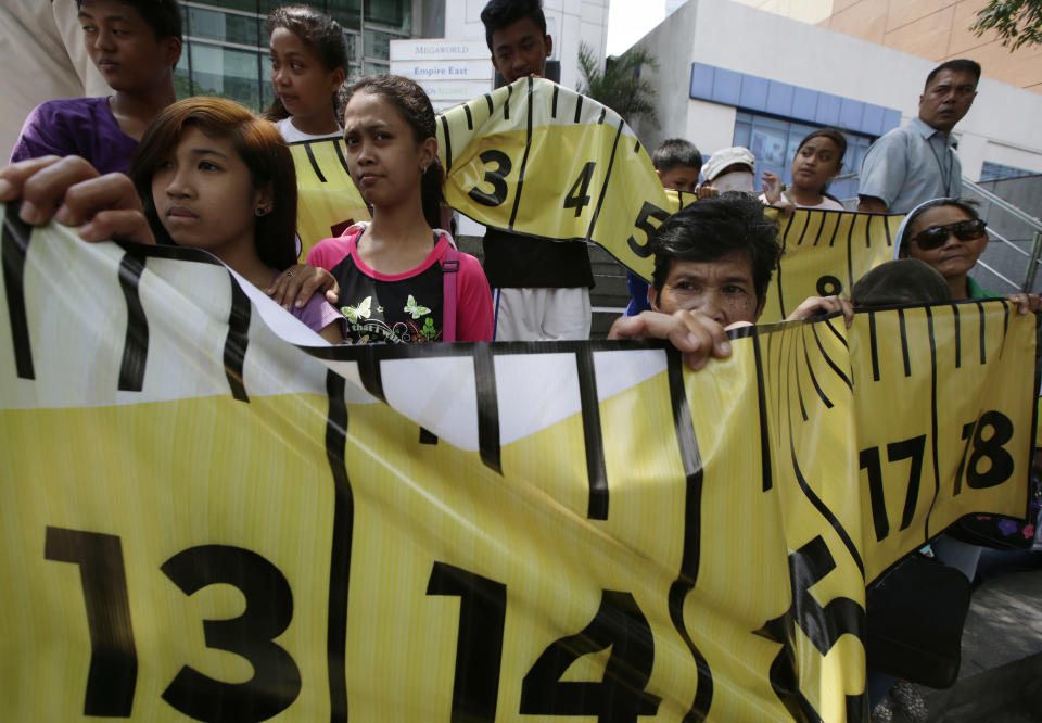 Protesters display a mock tape measure during a rally outside the Chinese consulate at the financial district of Makati city east of Manila, Philippines Wednesday, April 2, 2014. Dozens of Filipino left-wing activists protested at China's consulate to protest the blocking by Chinese coast guard ships of a Philippine supply boat near a disputed shoal in the South China Sea. (AP Photo/Bullit Marquez)