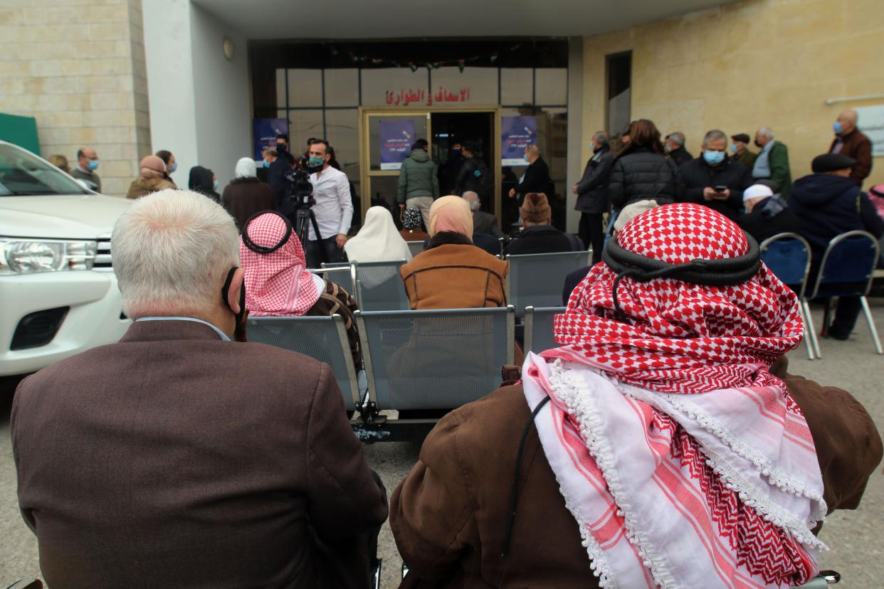 Elderly people sit in a queue to receive their free COVID-19 vaccination, as Jordan starts the national vaccination campaign at a special vaccination clinic on Jan. 13, 2021, in Amman, Jordan.