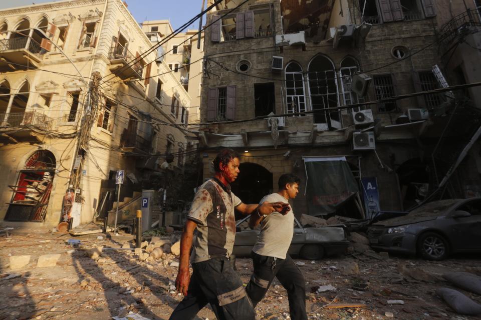 A wounded man is helped as he walks through debris in Beirut's Gemmayzeh district Tuesday.  (Photo: MARWAN TAHTAH/AFP via Getty Images)