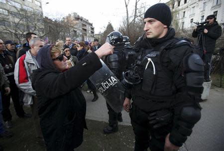 A protester speaks to a police officer in front of a government building in Sarajevo February 8, 2014. REUTERS/Antonio Bronic