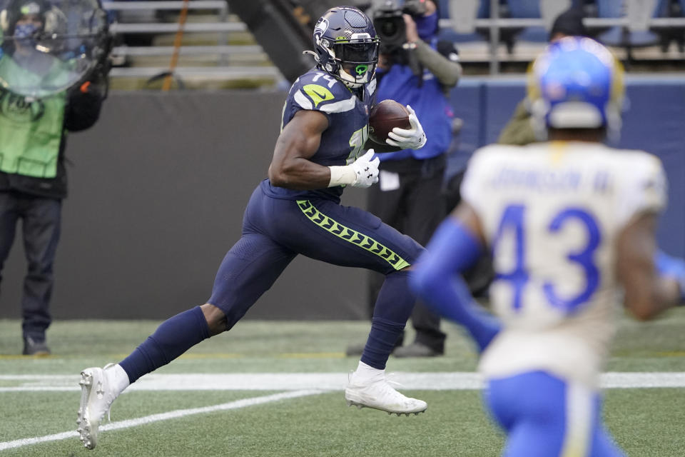 Seattle Seahawks wide receiver DK Metcalf, left, heads to the end zone to score against the Los Angeles Rams on a 51-yard pass reception during the first half of an NFL wild-card playoff football game, Saturday, Jan. 9, 2021, in Seattle. (AP Photo/Ted S. Warren)