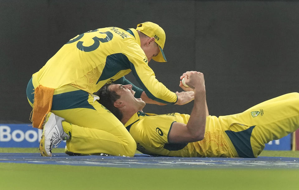 Australia's captain Pat Cummins celebrates the wicket of South Africa's wicketkeeper Quinton De Kock with his teammate Marnus Labuschagne after taking his catch during the ICC Men's Cricket World Cup second semifinal match between Australia and South Africa in Kolkata, India, Thursday, Nov.16, 2023. (AP Photo/Bikas Das)