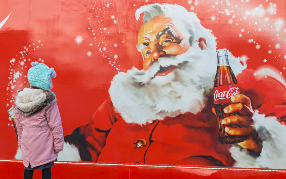 A little girl looking at the Christmas Coca Cola truck as it arrives in Bournemouth