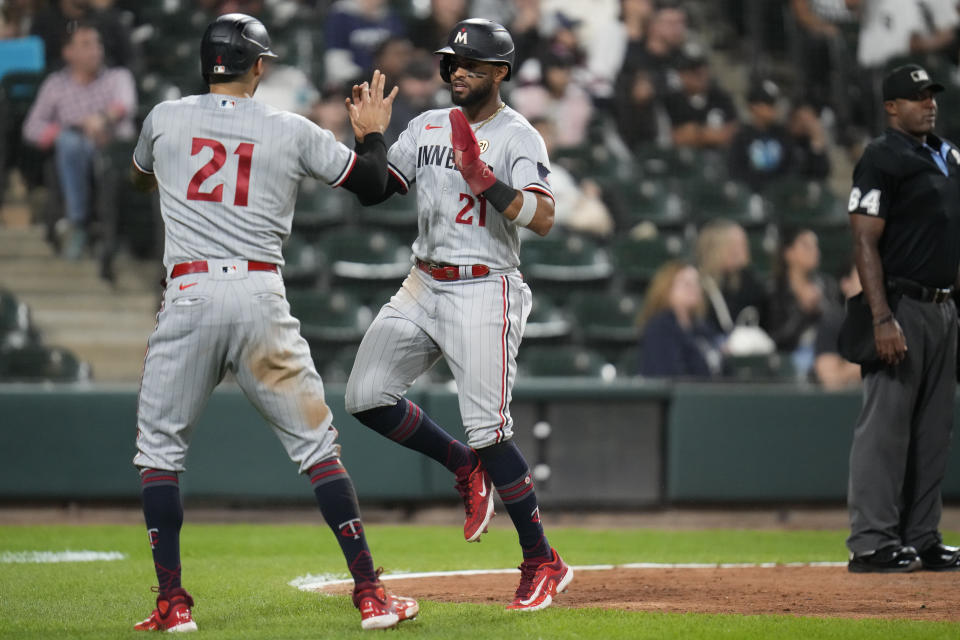 Minnesota Twins' Carlos Correa, left, and Willi Castro high-five after both scoring on a single from Ryan Jeffers during the ninth inning of a baseball game against the Chicago White Sox, Friday, Sept. 15, 2023, in Chicago. (AP Photo/Erin Hooley)
