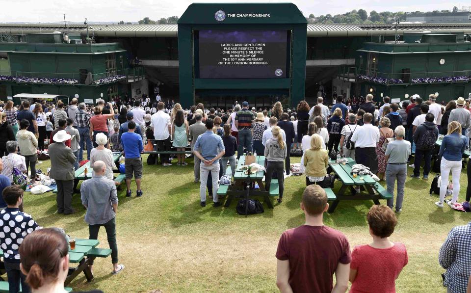 Spectators observe a minutes silence on 'Murray Mound' in memory of the 7/7 bombings in London at the Wimbledon Tennis Championships in London