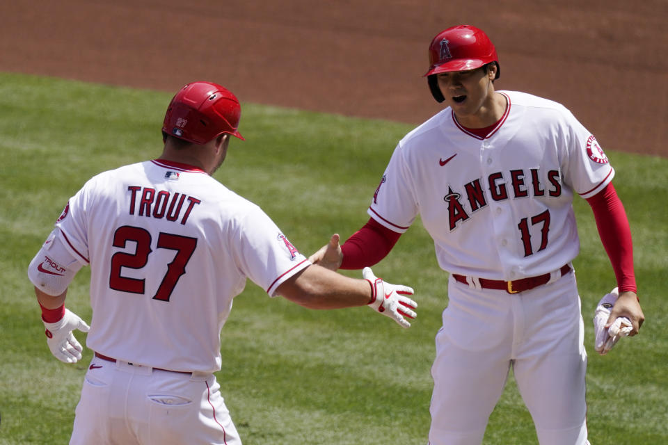 Los Angeles Angels' Mike Trout, left, is congratulated by Shohei Ohtani after hitting a two-run home run during the first inning of a baseball game against the Houston Astros Tuesday, April 6, 2021, in Anaheim, Calif. (AP Photo/Mark J. Terrill)
